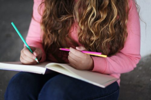 Frau arbeitet uund liest in Buch langes Haar fällt wellig am Körper herunter